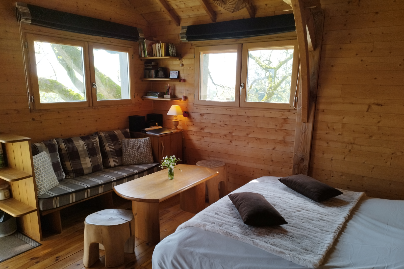 grand lit et salon de la cabane des chênes dans les arbres